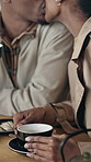 Kiss, talking and black couple in coffee shop, celebration for anniversary and relationship.  Relax, African man and woman in cafe, holiday and bonding together for commitment, honeymoon or happiness