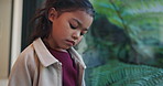 Lonely, sad and child by window in home with reflection of trauma, bad memory and negative emotions. House, childhood and girl with thoughtful, wondering and thinking for separation, alone and worry