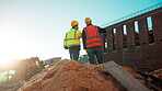 Men, team and discussion on construction site for planning, building development and space. Low angle, engineers and outdoor with meeting for inspection requirements, renovation progress and back
