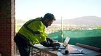 Engineer, man and typing on construction site with laptop, planning or research for renovation project. Person, browse or civil engineering in building with computer, infrastructure or online report.