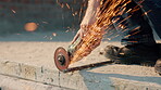 Hands, iron and grinder at construction site to cut material with power tools, sparks or contractor. Man, machine and industry for renovation, expansion or engineering for repair and maintenance