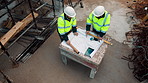 Architect, team and blueprint at construction site, discussion and development feedback from above. People, paperwork and floor plan with drawing for building design, engineering or layout review