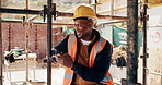 Engineer, man and typing at construction site with phone, scaffolding or check social media on break. Black person, smile and outdoor with tech, text message or building framework for infrastructure.