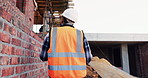 Engineer, man and inspection at construction site with PPE, property development and renovation project. Back, person and walk with engineering work, quality assurance and outdoor for infrastructure.