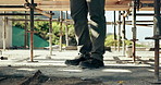 Walking, legs or worker by scaffolding at construction site, infrastructure evaluation or inspection. Feet, risk assessment or person with check for worksite safety, property or building progress