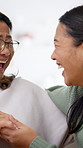 Adult, daughter and laugh with mother for funny conversation, family connection and visit in home. Happy, senior mom and women in house with joke communication, gossip or bonding together on weekend.