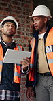 Civil engineer, inspection and men with tablet in building, collaboration or safety check on website. Architect, teamwork and happy people with tech for property development, pointing and discussion