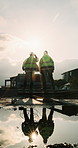 Back, construction and team celebration on site for foundation finish, inspection pass or support. Reflection, flare and excited men with fist pump for building progress, compliance success and space