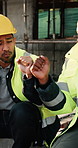 Construction, fist bump and men with lunch at site for break, relax and teamwork by building. Architecture, friends and people with food, snack and eating for energy for infrastructure project