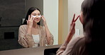Mirror, beauty and asian woman with eye patches in bathroom for collagen treatment in home. Female person, skincare mask or cosmetics with facial for hydration, vitamin C or hyaluronic acid in house