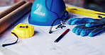 Architecture, helmet and blueprint with tools on table, infrastructure schematic or safety equipment. Construction, scale or gear for renovation project, tape measure or plan for property development