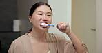 Bathroom, cleaning and asian woman with toothbrush for dental hygiene or morning routine in home. Female person, oral care or brushing teeth with smile for gums, fresh breathe or grooming in house