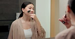 Skincare, facial or asian woman with jade roller or mirror for anti aging treatment in home. Female person, relax or massage with cosmetic beauty tool or reflection for lymphatic drainage in bathroom