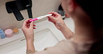 Health, pregnancy test and hands of woman in bathroom at house for good news, fertility or IVF success. Morning, pregnant and person with positive result for future planning with wellness in home.