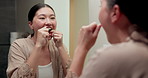 Mirror, cleaning and asian woman with dental floss in home for oral or gum care in bathroom. Female person, string or morning routine with reflection or cavity for bacteria or germ removal in house