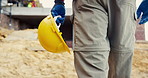 Helmet, hands and person on construction site for safety, infrastructure and property inspection. Architecture, civil engineering and walking with PPE equipment, renovation and remodeling project