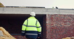 Civil engineer, walk and man in construction site, inspection and planning for property development. Person, back and safety check for building renovation, architecture or real estate quality control