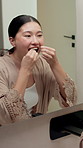 Bathroom, floss and Asian woman in mirror in morning for dental hygiene, gum disease and oral care. Reflection, health and person with string for wellness, cleaning and cavity prevention in home