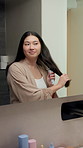 Smile, haircare and Asian woman in bathroom with brush, natural growth and frizz control for beauty. Happy, person and brushing hair in home with cosmetics, grooming maintenance and mirror reflection