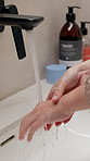 Water, hygiene and woman washing hands in bathroom at house for health, self care or disinfection. Tap, safety routine and female person cleaning skin for removal of bacteria, dirt or germs in home.