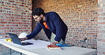 Typing, laptop and man with blueprint at construction site, planning update and change for renovation. Engineering, remodeling or architect writing for schematic revision, pc or property development