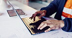 Architect, hands and typing on laptop for review, design update or schedule for property development. Man, computer and engineer with blueprints for compliance regulations with maintenance research