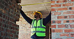 Frame, engineer and tape measure at construction site for precision, dimension and layout for building. Black man, doorway and tools for measurement, structure and property development or renovation