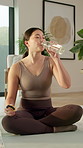 Fitness, drinking and woman with water in home for health, wellness or diet on weekend by yoga mat. Break, relax and Asian female person with beverage in bottle for hydration in living room at house.