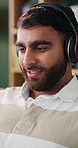 Headphones, man and remote work in home, smile or songwriter with inspiration for audio melody. Reading, music and happy freelancer at apartment with online playlist, creative sound and song lyrics