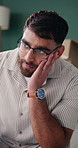Mental health, thinking or man in house with regret, anxiety trigger and memory of past trauma. Flashback, glasses or male person with depression, overthinking and emotional fatigue in living room.