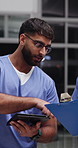 Nurse, team and talk in hospital with clipboard, planning and research for health insurance at night. Late, men and discussion in clinic with tech, checklist and review report for medical aid policy.