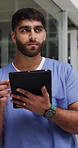 Nurse, man and thinking in hospital with tablet, medical research or planning patient care at night. Late, person scroll or problem solving in clinic with tech, telehealth app or healthcare decision.