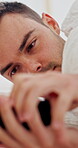 Wake up, man and snooze phone in bed for lazy morning, resting or exhausted from insomnia. Sleepy, person or turn off alert in home for alarm clock, app notification and delay to start day in bedroom