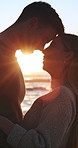 Love, travel and couple with sunset on beach for romance, date and anniversary vacation or bonding together. Trip, smile and happy people with affection for weekend holiday, loyalty and support