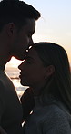 Smile, travel and couple with sunset on beach for romance, date and anniversary vacation or bonding together. Trip, love and happy people with affection for weekend holiday, loyalty and support