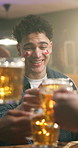 Beer, night or happy man with cheers in pub for celebration, sport entertainment or social gathering. Excited, male person or group of fans with alcohol or toasting for winning or good game in bar