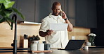 Man, paperwork and laptop in home with phone call, budget and verification of utility bills invoice. Black person, talk or contact in kitchen with tech, document or confirmation of household expenses