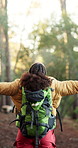 Backpack, hiking and woman in nature for freedom, holiday adventure and explore for wanderlust goal. Back, trekking and person in forest with open arms, walking or travel with journey success