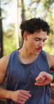Fitness, man or running with watch in forest for hiking, heart rate or tracking performance. Active, male person or runner monitoring calories with wristwatch for outdoor exercise, health or wellness