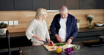 Talking, home and old couple with vegetables, cooking and healthy with tablet, recipe and cutting. Support, advice and senior people in kitchen, skills and ingredients with meal prep and discussion