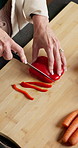 Hands, cooking and bell pepper on chopping board for wellness, healthy diet or nutrition in kitchen. Cut vegetables, woman and meal prep with knife at home, organic and natural vegan food from above