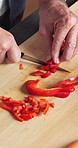 Hands, cooking and bell pepper on chopping board for diet, healthy nutrition or wellness in kitchen. Cut vegetables, man and meal prep with knife at home, organic and natural vegan food from above