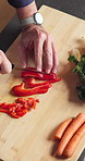 Hands, cooking and bell pepper on chopping board for nutrition, healthy diet or wellness in kitchen. Cut vegetables, man and meal prep with knife at home, organic and natural vegan food from above