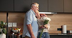 Smile, flowers and elderly couple in home for hug, support or bonding together in kitchen. Love, commitment and senior man with woman for gift with marriage, anniversary and bouquet in apartment