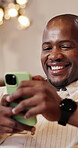 Man, laughing and chat with phone, home and communication with contact on social media and browsing. Typing, online and black person with mobile, networking and reading funny message on web in lounge