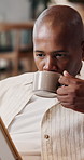 Drinking, coffee and man with tablet in house, laugh and watching movie with subscription in lounge. Happy, black person and streaming funny video in living room, online and relax with tea in home
