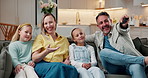 Parents, children and watching tv on couch with remote, family bonding and laugh for funny cartoon. Happy people, father and mother in house with girl kids, comedy show and tech for streaming movie.