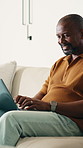Remote work, thinking and man in home on laptop for internet, networking and website for research. Mature, house and African person with computer for online report, planning and freelance project