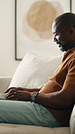 Remote work, sofa and man in home on laptop for internet, networking and website for research. Mature, house and African person with computer for online report, proposal and freelance project