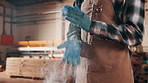 Carpentry, sawdust and hands of person in workshop for manufacturing, furniture repair and building. Factory, carpenter and man with gloves, dust and timber for woodworking and lumber production